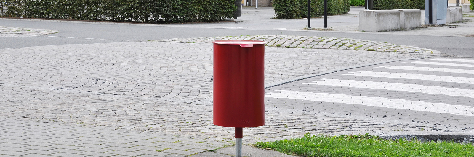 A red litterbin Poppel in an urban environment.
